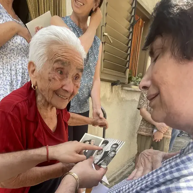 Carrie’s mother and Aunt Rosa compare old family photos on the doorstep in Alessandria del